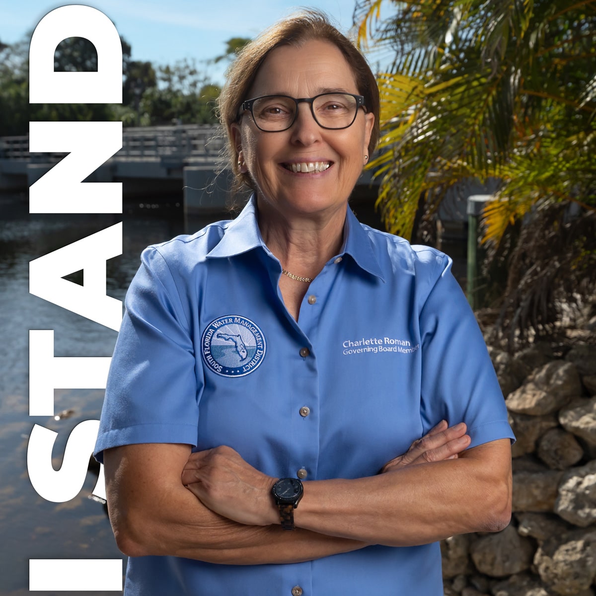 Charlette Roman - Board Chair of South Florida Water Management District - standing in front of a canal and the words "I Stand" behind her.