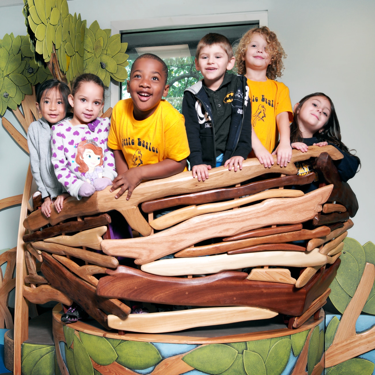 A group of children hanging out in the eagle's nest inside the Little Explorer Play Zone.