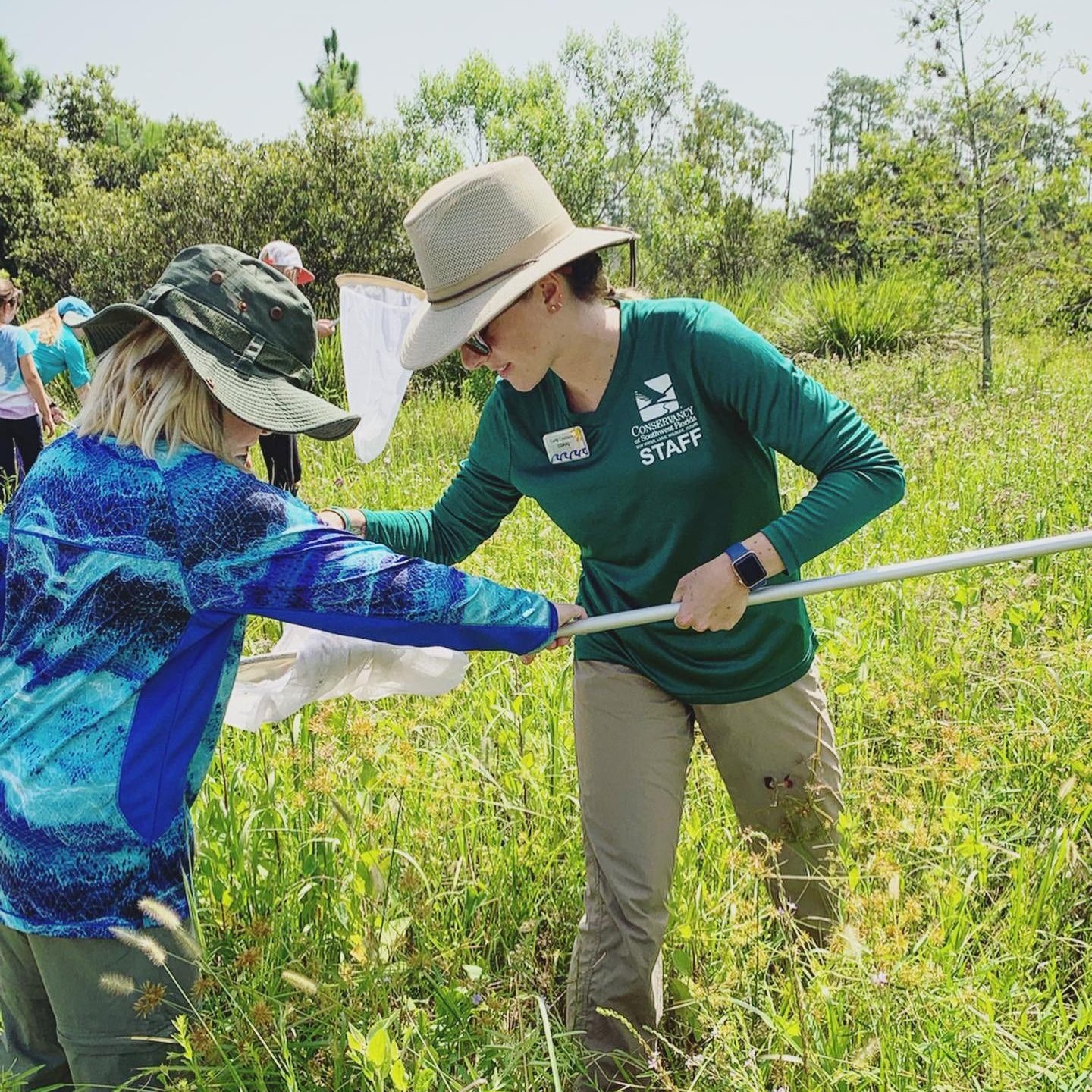 Conservancy of Southwest Florida education staff member checking a butterfly net with a student